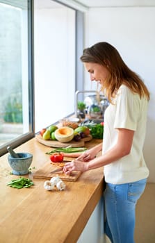 Smile, home and woman with vegetables, cutting and salad with organic ingredients, healthy meal and food. Wellness, vegetarian and person in kitchen, nutrition and diet with knife, cooking and chef.