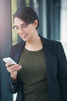 Happy woman, business and browsing with phone for social media, communication or news at office. Female person or employee with smile on mobile smartphone for online chatting or texting at workplace.