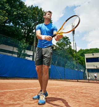 Man, sports and serve in outdoor tennis match, game and court for competition or practice. Male person, athlete and ready for training or exercise, workout and start for action and low angle fitness.