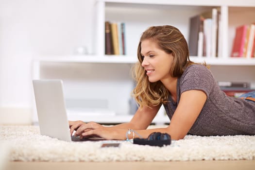 Laptop, student and woman on floor for online learning, education and studying in home living room. Typing, lecture class for university on carpet, female person or relax for course work on website.