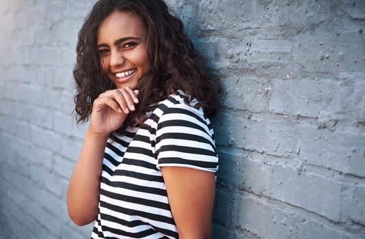 Girl, portrait and smile or city brick wall with laughing humor or funny joke for traveling vacation, confidence or downtown. Female person, face and happy in New York for weekend, outdoor or urban.