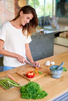 Cooking, home and happy woman with food, meal prep and cutting fresh vegetables for gut health. Diet, digestion and female person in kitchen with ingredients, nutrition and wellness in apartment