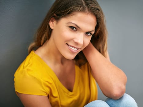 Wall, smile and woman on floor, portrait and relax for weekend, Gen z and streetwear for fashion in house. Grey background, happiness and girl in apartment, cheerful and comfortable on ground of home.