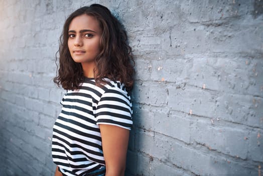 Brick, wall background and portrait of girl in city with fashion, trendy clothes and casual style. Student, college and woman in urban town with confidence, pride and attitude outdoors on weekend.