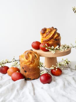 Festive table setting, Easter pastries on a wooden stand and cherry blossoms. Easter holiday concept