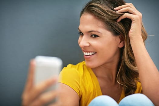 Happy, confidence and woman with selfie in studio for content creation, memory and online post. Influencer, relax and smile in photography for social media, network and update on grey background.