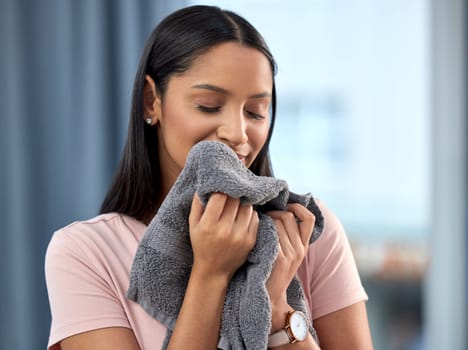 Laundry, fresh linen and woman smelling towel after spring cleaning, housework and washing clothes in the morning. Chores, housekeeping and happy with female person with clean scent in home