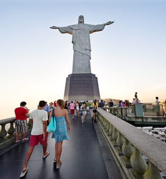 People, christ and statue with tourist in rio de Janeiro of redeemer for sightseeing, landmark or view of sculpture. Group, community or crowd on tour, trip or monument of iconic attraction in Brazil.