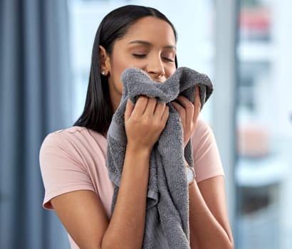 Fresh linen, laundry and happy woman with towel after spring cleaning, housework and washing clothes in the morning. Chores, housekeeping and female person with hygiene, scent and wash cloth at home.