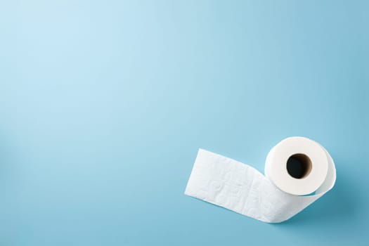 Top view of toilet paper roll on blue background