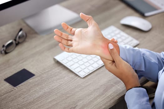 Hands, wrist pain and injury at desk in office with red glow, overlay and massage with burnout. Person, arthritis or carpal tunnel syndrome with emergency, strain and fatigue by computer in workplace.