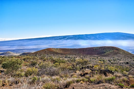 Hill, crater and landscape of mountain in countryside or morning fog on inactive volcano in Hawaii. Nature, horizon and travel to bush in valley with grass, plants and summer mist in blue sky.