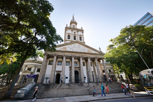 Church, sunshine and people with tourism, travel and architecture in Rio de Janeiro, street and landscape. Buildings, location or vacation with holy temple, sanctuary and summer with break or outdoor.