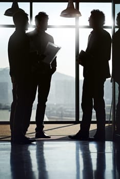 Businessman, silhouette and meeting by window in office with documents by talking or planning with partners for project strategy. Team, men and workshop or conference for ideas on company development.