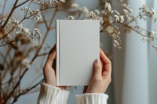 Hand holding white blank book mockup, isolated