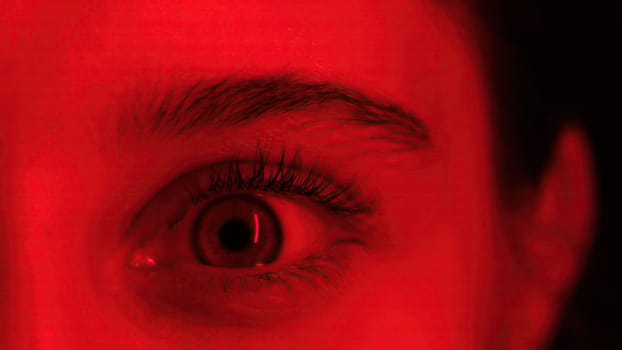 Young Girl Widely Opens Her Big Eye In Red Light, Seen In A Close-Up View