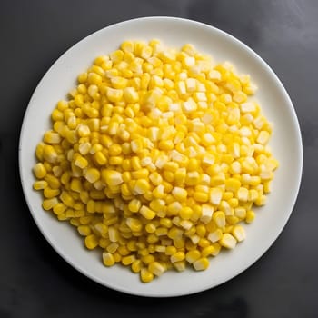Yellow corn kernels on a white plate, top view. Corn as a dish of thanksgiving for the harvest. An atmosphere of joy and celebration.