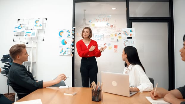 Young beautiful leader presents marketing strategy while expert investor and project manager listening and lecturing to analyze business performance at start up business meeting. Immaculate.