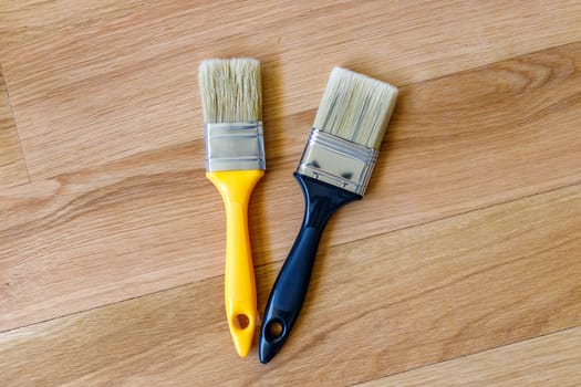 Top view of clean new paint brushes on wooden background
