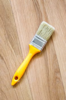 Top view of clean new paint brush on wooden background
