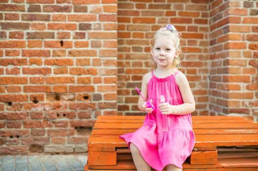 Child girl walks and have fun outdoor with cochlear implant on the head. Hearing aid and treatment concept. Copy space vertical.