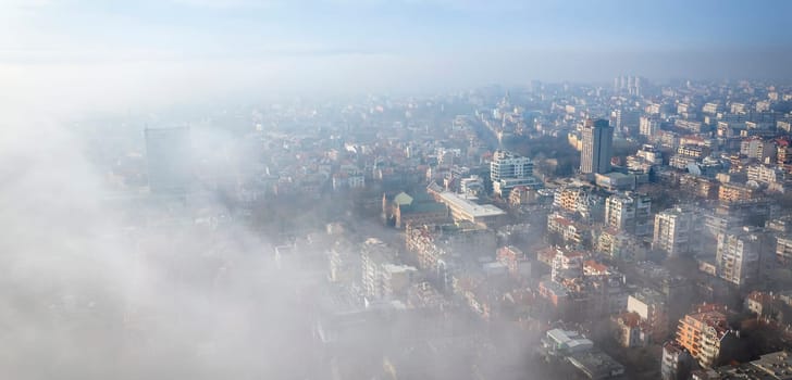 Fog clouds over the city from the sea, view from above