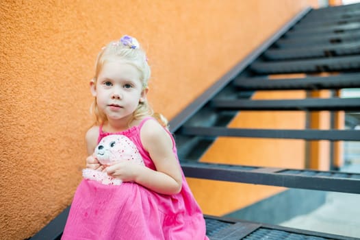 Child girl walks and have fun outdoor with cochlear implant on the head. Hearing aid and treatment concept. Copy space vertical.