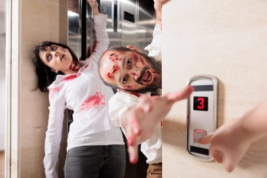 Actors playing zombies in horror movie scene coming out of elevator to infect employees. Man and woman with undead creature role in disaster film leaving escalator to kill humans