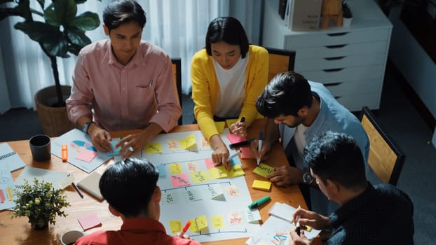 Close up of professional business team hands writing and putting sticky note on scrum task board. Top view of project manager write task and use kanban board to manage time and workflow. Convocation.