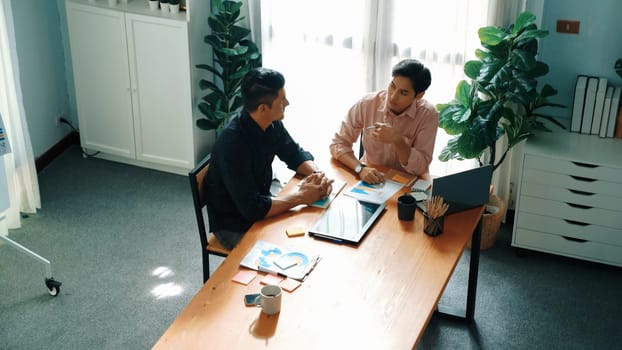 Group of diverse people sharing idea while writing at sticky notes. Professional smart business team brainstorming idea and planning strategy for startup project while wear casual outfit. Convocation.