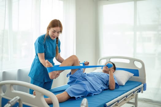 A sick caregiver or young nurse is helping a patient who is rehabilitating with physical therapy at the hospital..