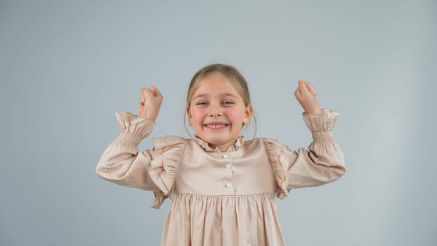 Little Caucasian girl having fun and making faces on a white background