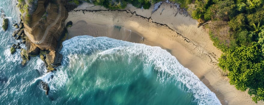 Aerial view of waves crashing on a tropical beach with rocky cliffs and lush forest