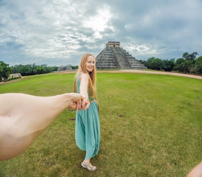 Beautiful tourist woman observing the old pyramid and temple of the castle of the Mayan architecture known as Chichen Itza. These are the ruins of this ancient pre-columbian civilization and part of humanity.