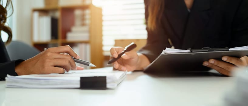 Closeup shot of businesswomen discussing financial papers at co working space.