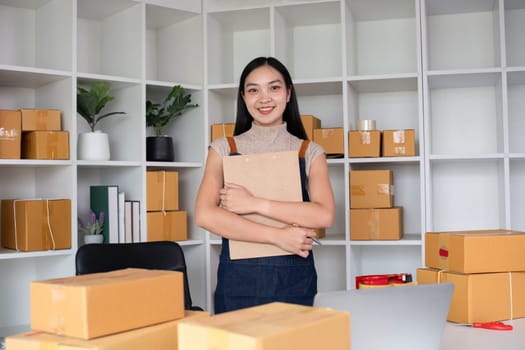 Confident small SME business owner stands holding a clipboard with inventory and shipping information in his home office. Small entrepreneurs prepare to deliver to customers..