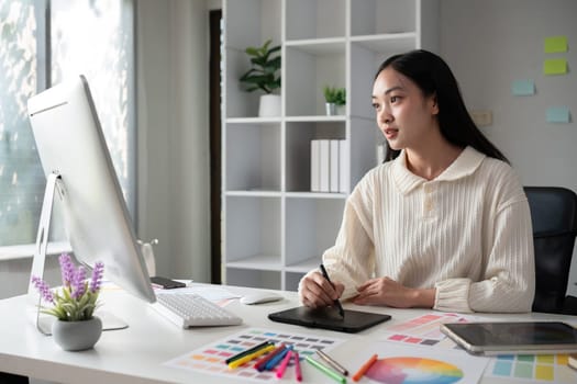 designer working in graphic design Choose colors for working with computers at your office desk.