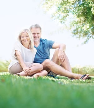 Senior, happy couple and portrait with relax on grass field for bonding, love or hug in outdoor nature. Man and woman with smile on lawn for embrace, care or support in relationship or retirement.