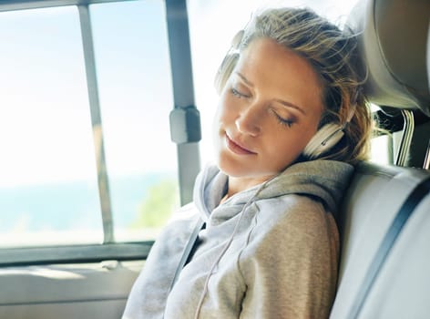 Headphones, relax and woman in car for road trip in summer listening to music, radio or podcast. Calm, sleeping and female person streaming album or song in van driving to vacation or holiday