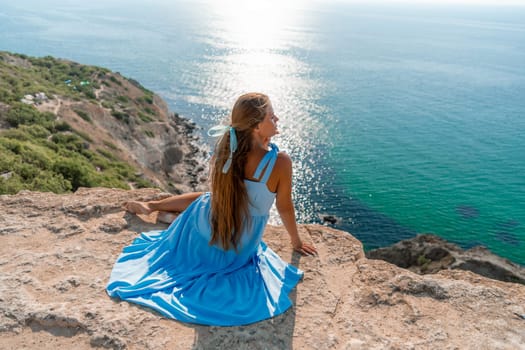 Woman travel sea. Happy woman in a beautiful location poses on a cliff high above the sea, with emerald waters and yachts in the background, while sharing her travel experiences.