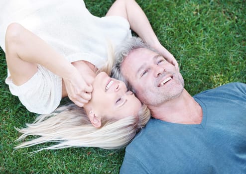 Man, woman and mature marriage on grass from above for relaxing break or day off weekend, travel or meadow. Happy couple, field and laughing for funny joke in Australia for humor, connection or date.