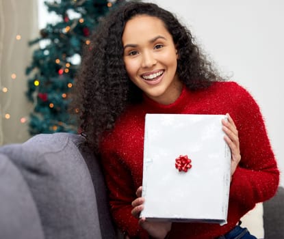 Woman, home and Christmas present in portrait, guess and surprise for Christian holiday celebration. Festive, packaging and gift giving for xmas, winter and vacation with excited in living room.