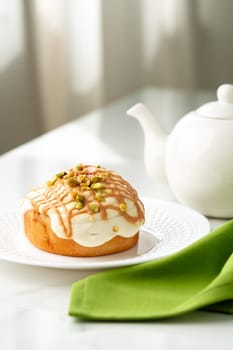 Cinnamon roll bun with icing on plate close up