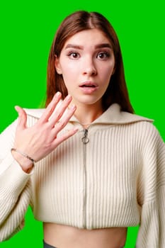 A woman wearing a white sweater is gesturing with her hand, possibly expressing emotion or emphasizing a point. Her hand movement is clear and deliberate. She appears focused and engaged in her communication.
