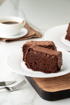 Fresh homemade chocolate sponge cake on wooden board close up