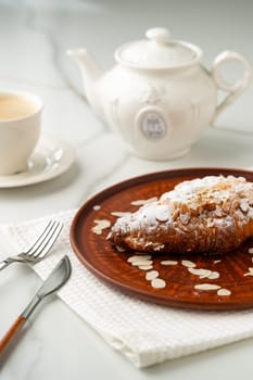 Almond Croissant on clay plate close up photo