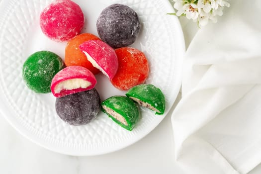 Multi-colored Japanese cakes Mochi in a white plate close up