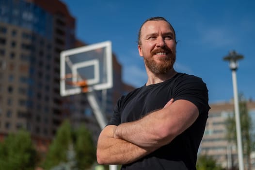 Portrait of a Caucasian bearded man on a basketball court outdoors