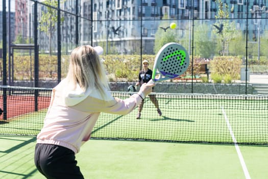 Ukraine Kyiv, April 20 2024. Portrait of smiling woman paddle tennis player during couple match at court. High quality photo