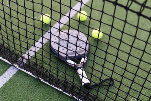 Paddle tennis racket, ball and net on the grass . High quality photo